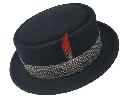 A black flat top Pork Pie fedora hat with a patterned band and a red feather decoration on the side.