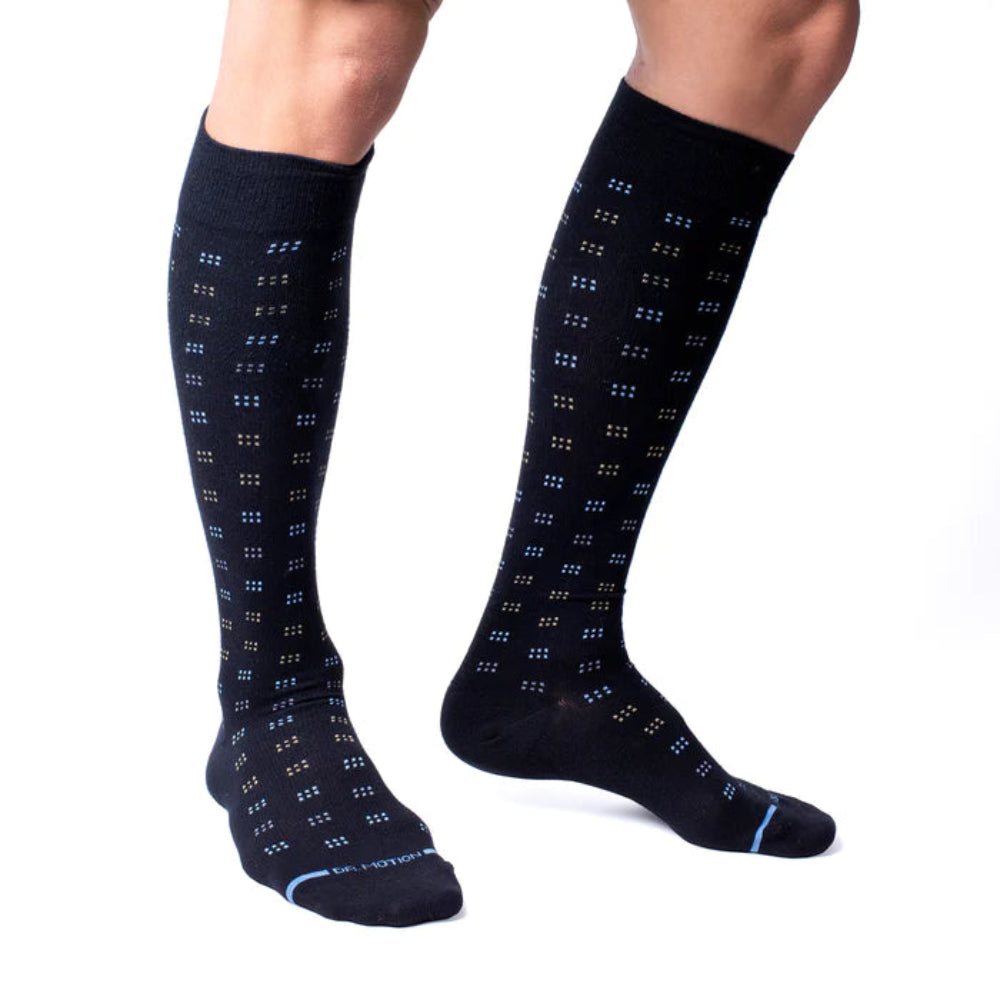 Black knee-high socks with blue pattern worn by a person on a white background