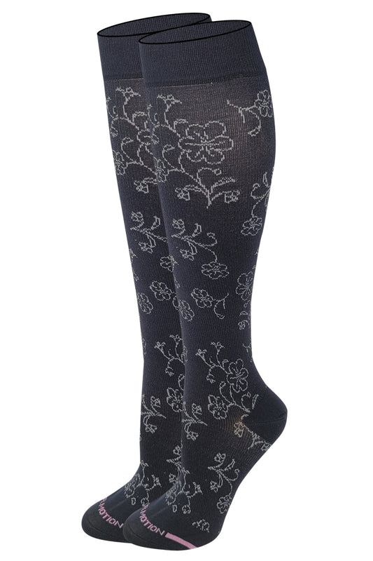 A pair of dr motion knee-high compression socks with a floral pattern in black color.